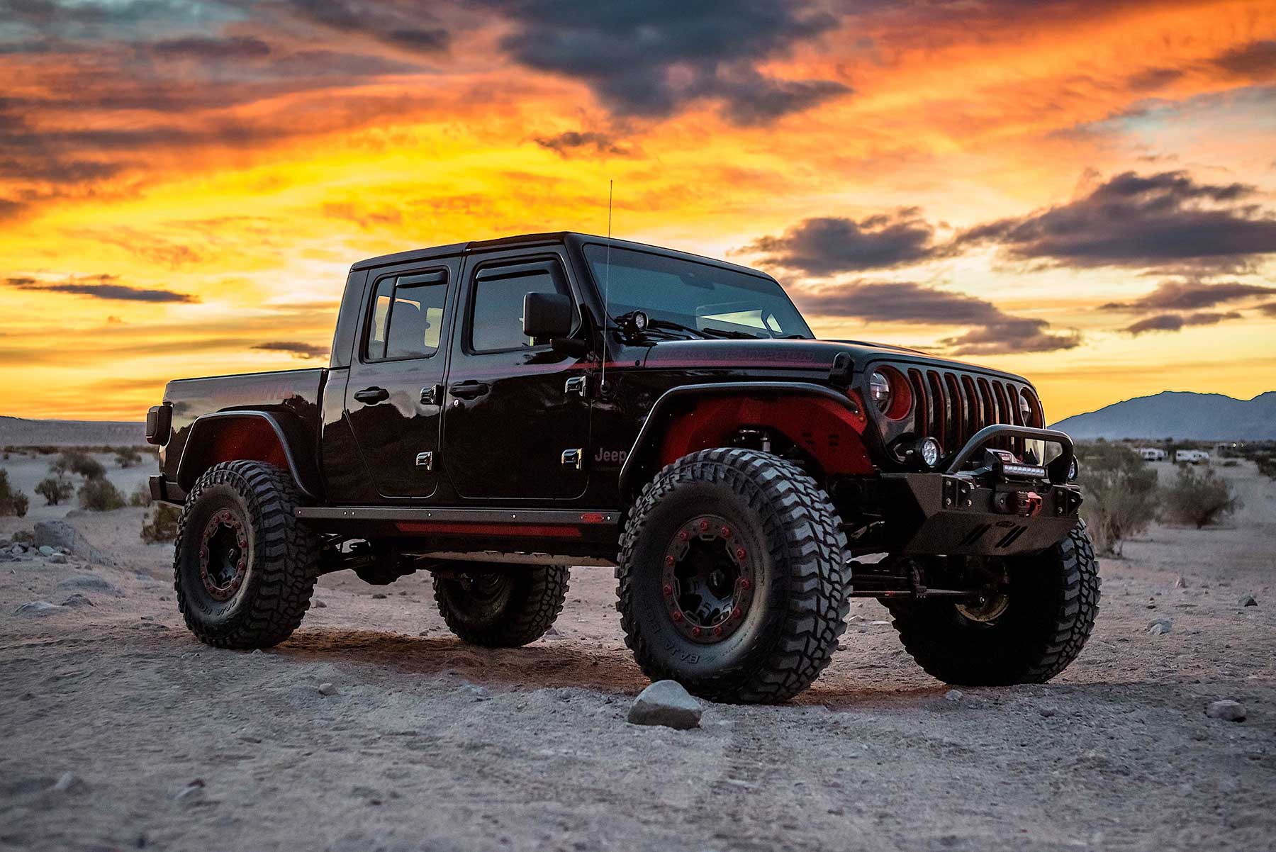 Custom black Jeep Gladiator on 35-inch tires under a blazing Las Vegas desert sunset