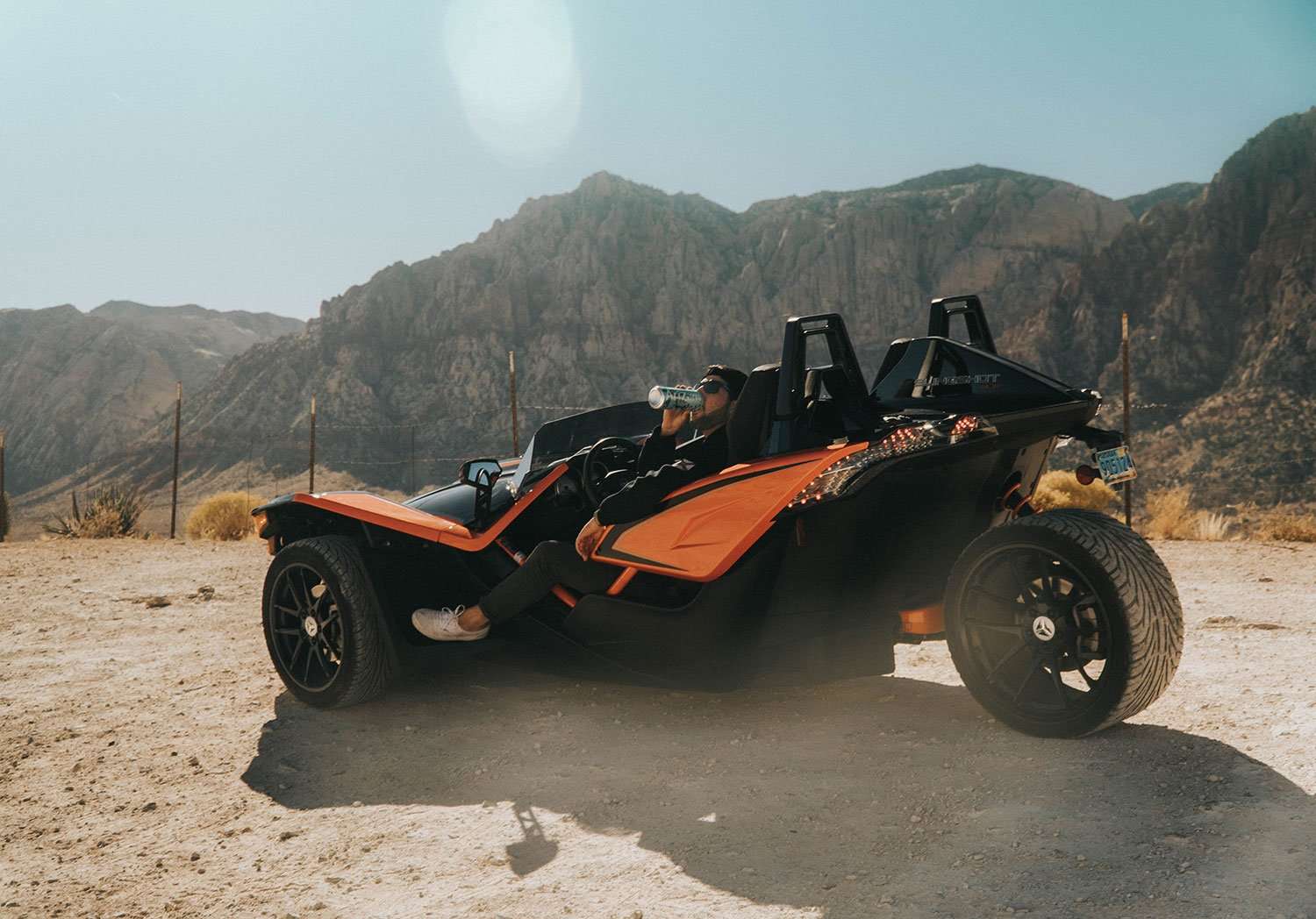 Orange Polaris Slingshot parked in the Las Vegas desert